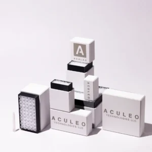 Stack of white and black Aculeo Technologies LLC mosquito control product cartridges and modules arranged neatly on a light surface with soft shadows.