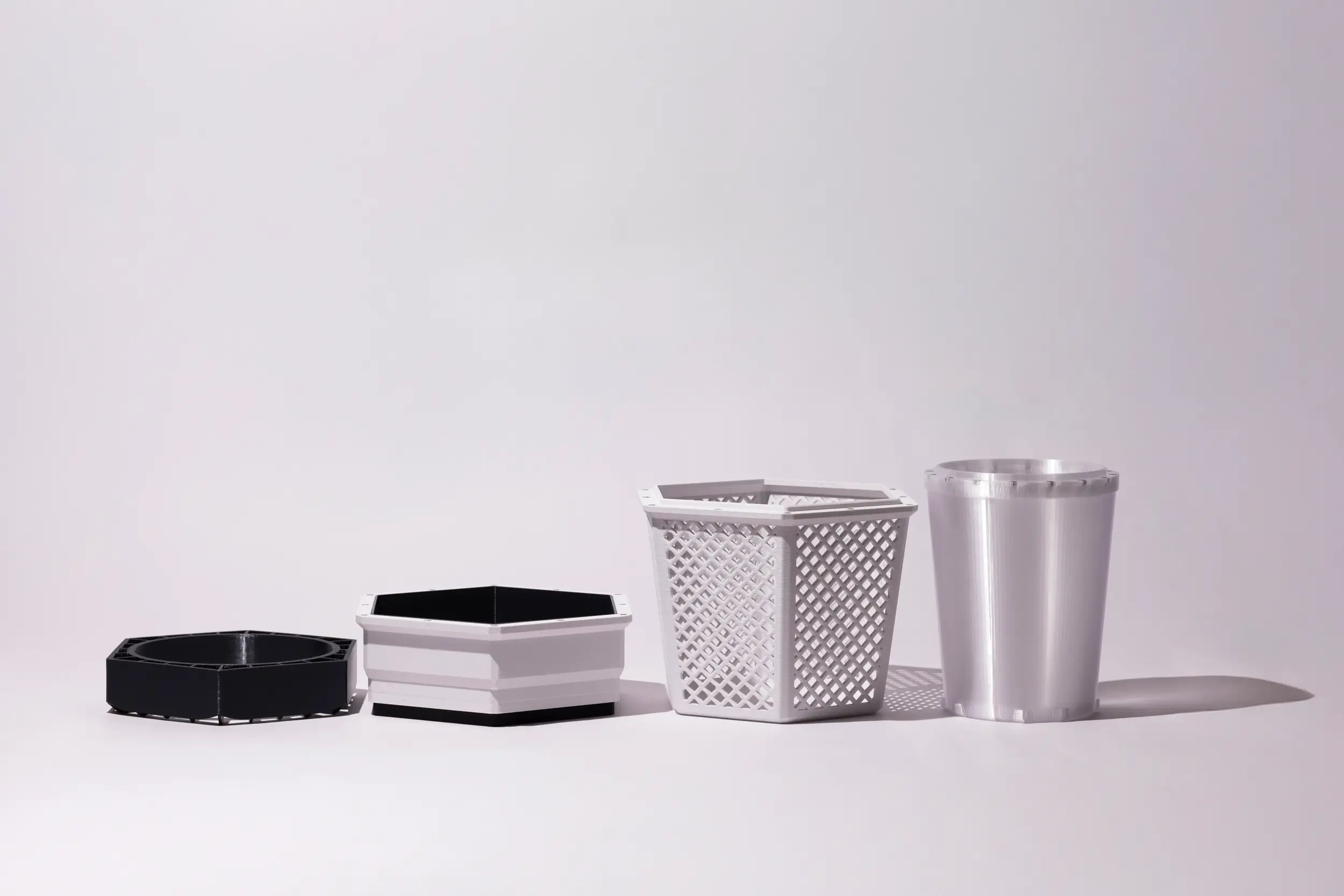 Four BuzzBox components displayed in a row, showing the base, midsection, lattice cover, and internal container.